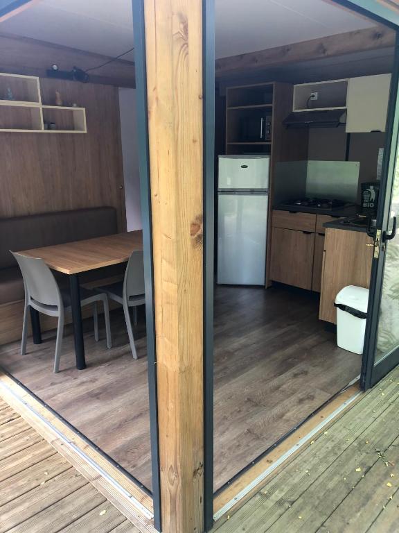 a view of a kitchen and dining room with a table at Camping Les Berges Du Doux in Colombier-le-Vieux