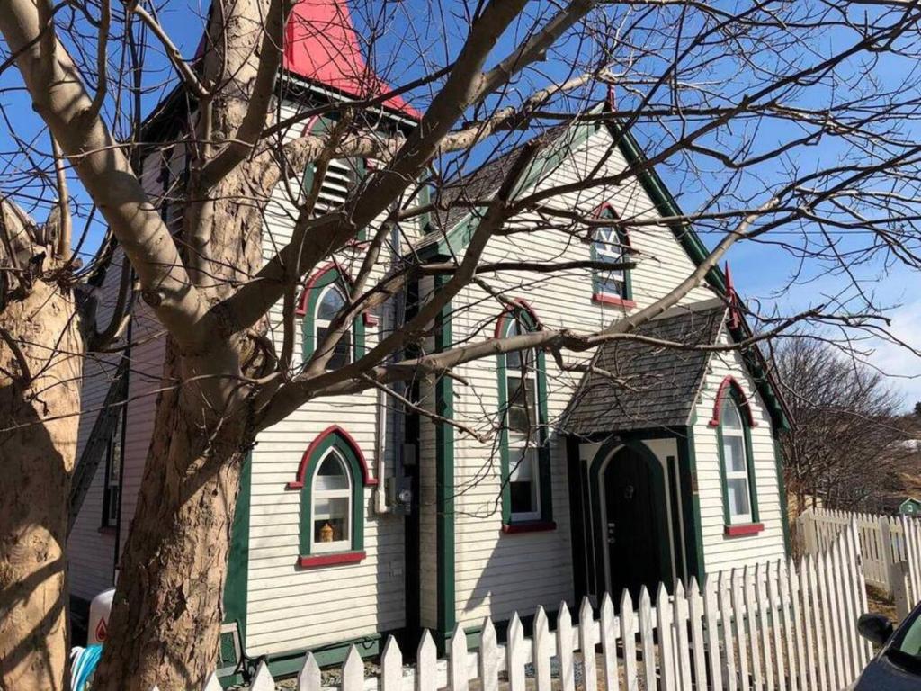 a white church with a red roof and a white fence at Unique Stay! Converted Church In Idyllic Location in St. John's