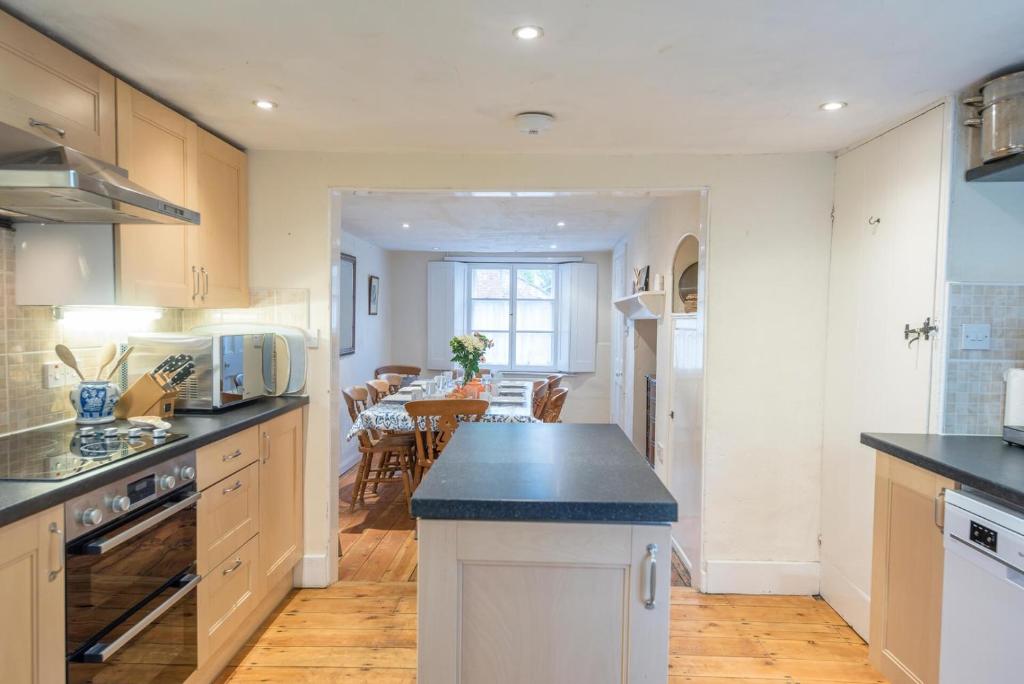 a kitchen with white cabinets and a dining room at Varley House, Saxmundham in Saxmundham
