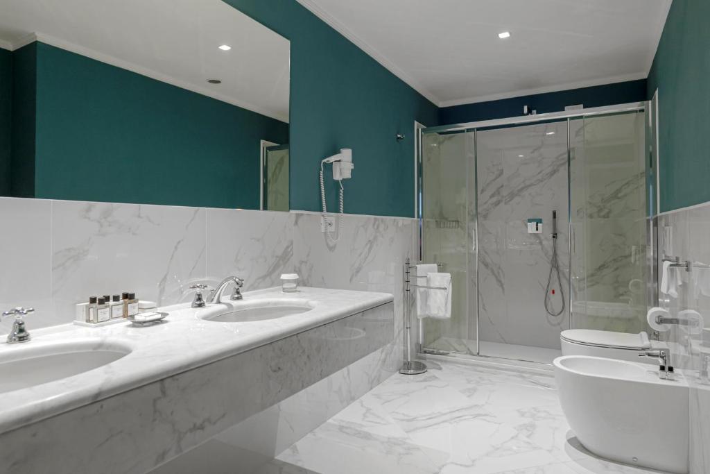 a bathroom with two sinks and a shower at Hotel Sina Astor in Viareggio