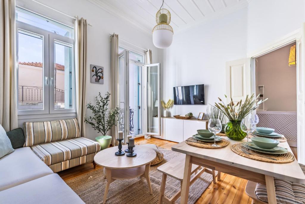a living room with a white couch and a table at Chora Residence in Skopelos Town