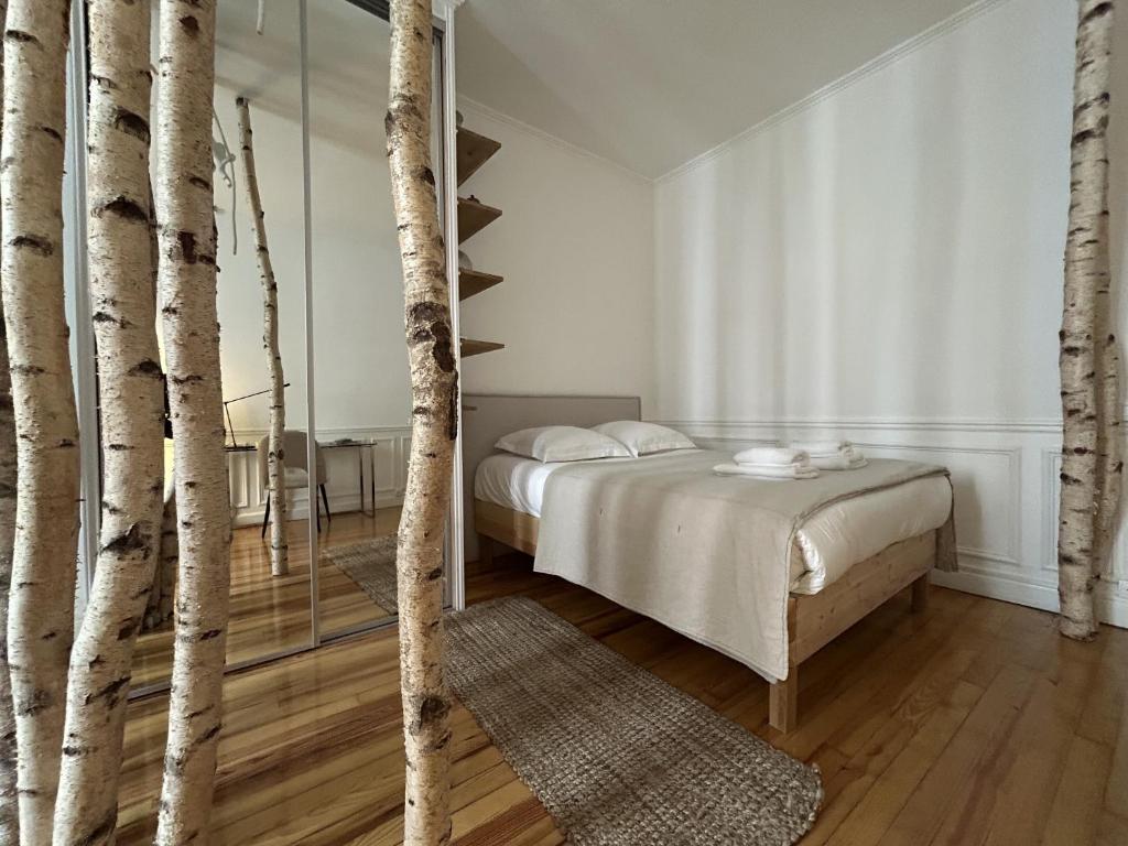 - une chambre avec un lit et quelques arbres dans l'établissement La Suite Carmen - Hypercentre de Reims, à Reims