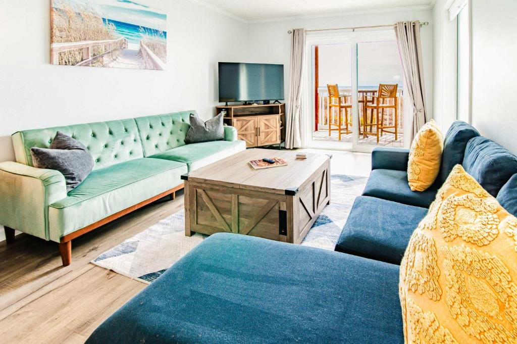 ein Wohnzimmer mit blauen Sofas und einem Tisch in der Unterkunft Windy Waves Top Location w Pool in Myrtle Beach