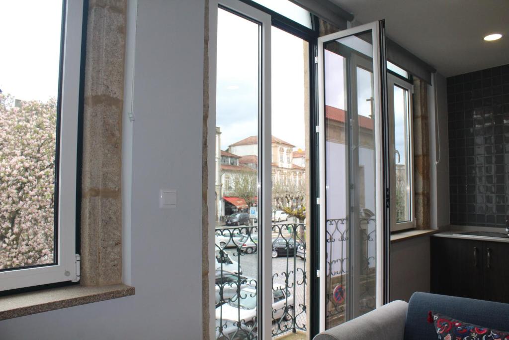a room with a balcony with a view of a city at Casinhas Dom Afonso by Hotel Dom Afonso in Monção