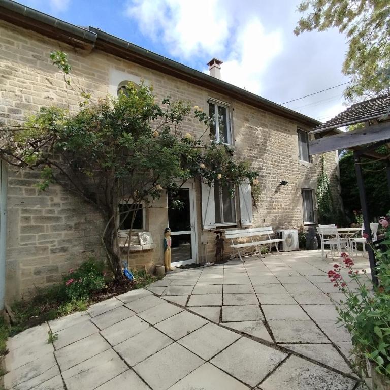 une maison en briques avec une terrasse en face de celle-ci dans l'établissement Domaine de Juliette, à Confracourt