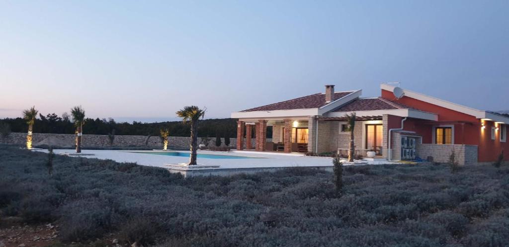 a house in the middle of a field with palm trees at Villa Melody Novalja in Novalja