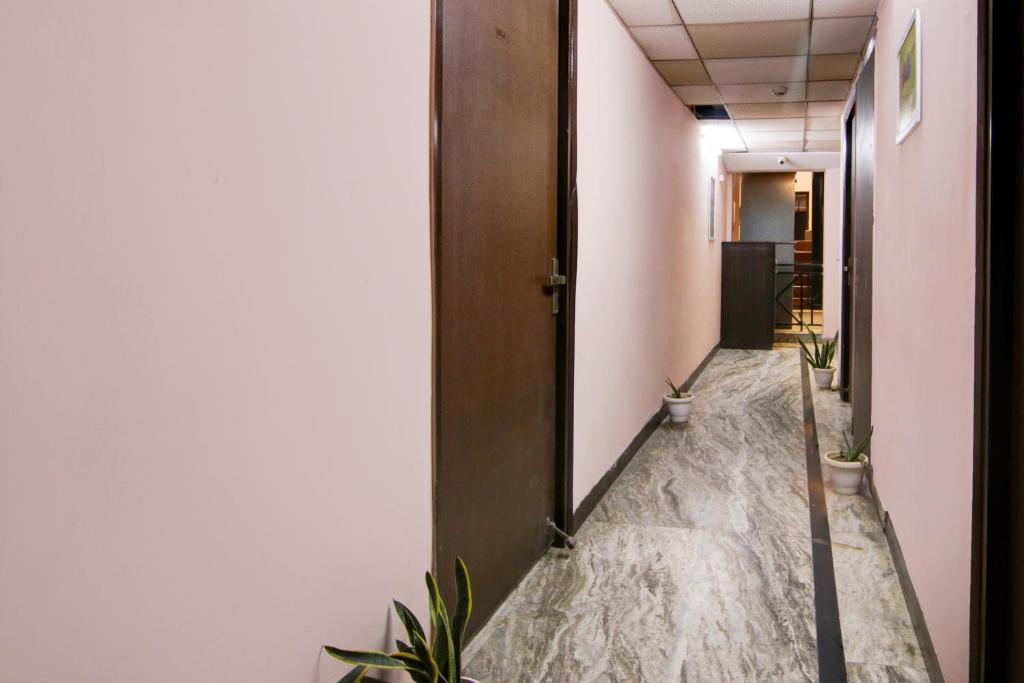 a corridor of an office with a mirror and plants at Hotel O Manya Stay in New Delhi