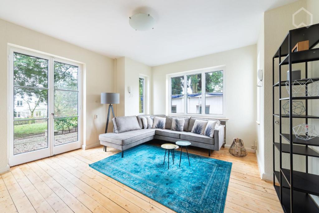 a living room with a couch and a blue rug at ZEN Villa - Garten - Kamin - idyllisch - 5 Zimmer in Bremen