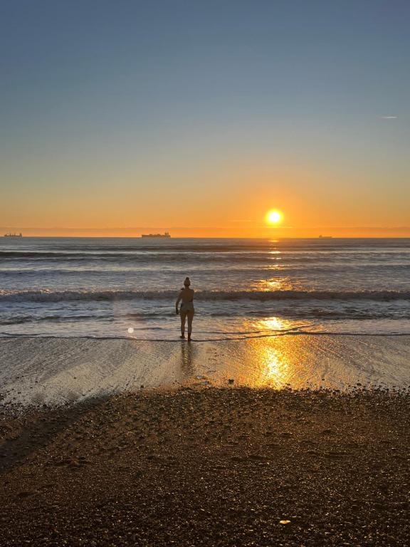 a person standing on the beach watching the sunset at Kelston Guest House in Weymouth