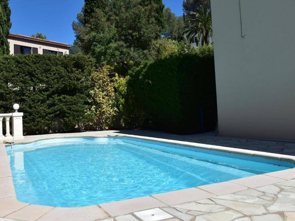 une piscine avec de l'eau bleue dans une cour dans l'établissement Haut de Villa - Proche plages, Piscine privée, à Saint-Raphaël