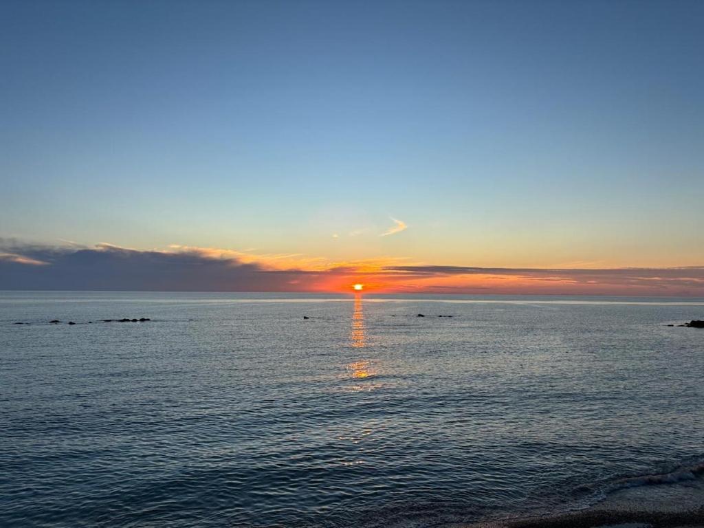 a sunset over the ocean with the sun setting at Penthouse Apartment A due passi dal Mare in Alghero