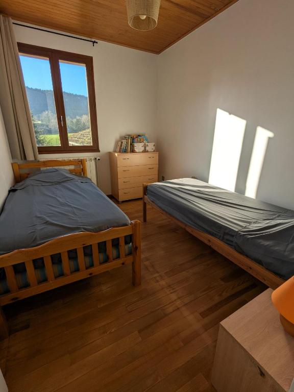a bedroom with two beds and a window at Camping Les Berges Du Doux in Colombier-le-Vieux