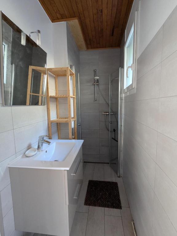 a white bathroom with a sink and a shower at Camping Les Berges Du Doux in Colombier-le-Vieux