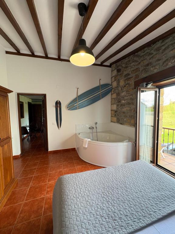 1 dormitorio con cama y bañera en Posada Punta Liñera, en San Vicente de la Barquera