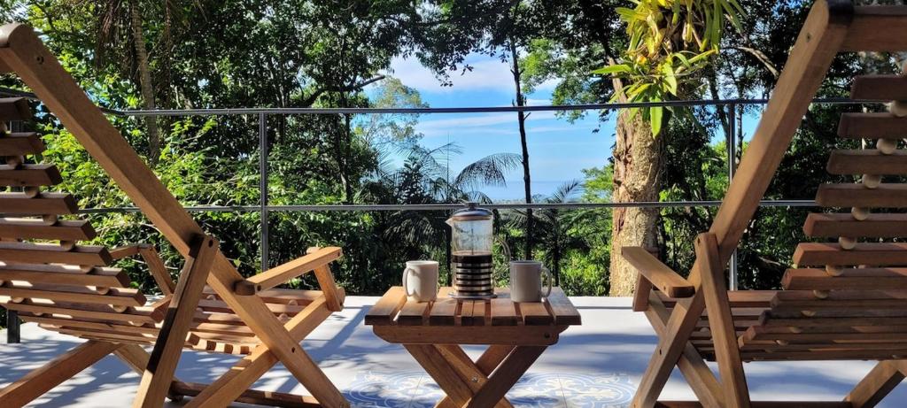 une paire de chaises et une table sur une terrasse dans l'établissement Casa em Maresias com vista pro mar, à São Sebastião