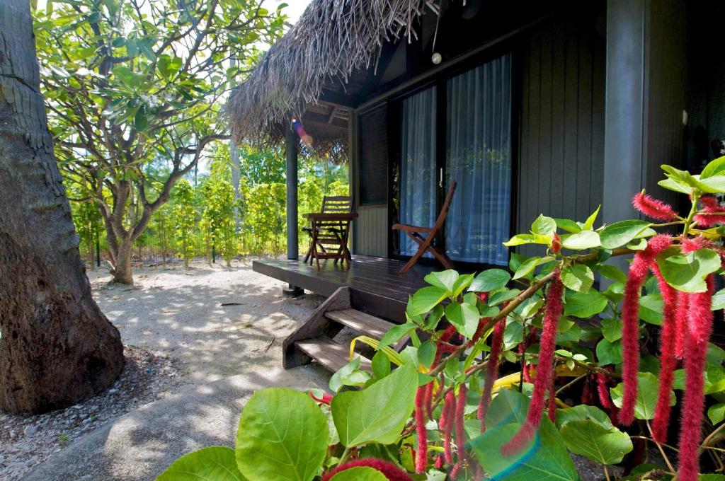 a porch of a house with a bench and some plants at Maitai Rangiroa in Avatoru