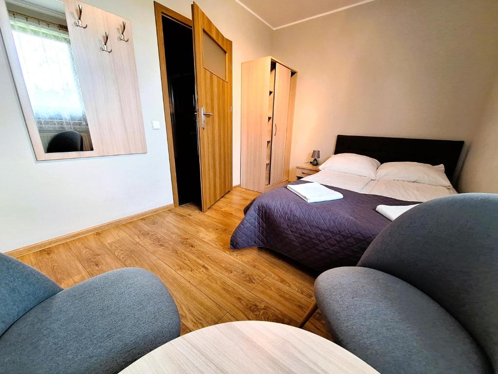 a bedroom with a bed and two chairs in it at Willa Maczek in Sztutowo