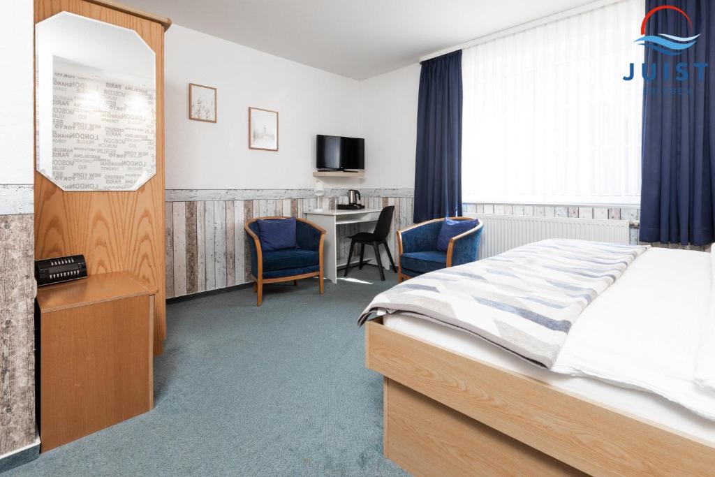 een slaapkamer met een bed, een tafel en stoelen bij Töwerland Zimmer 2 in Juist