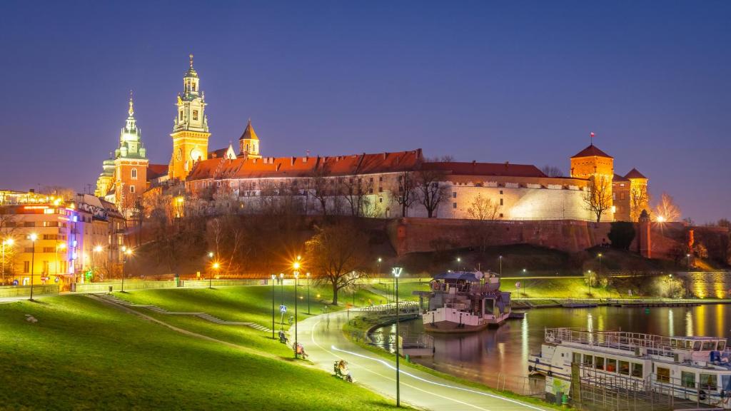 a view of a castle and a river at night at Twoje prywatne SPA - jacuzzi, sauna, tężnia solankowa in Kraków