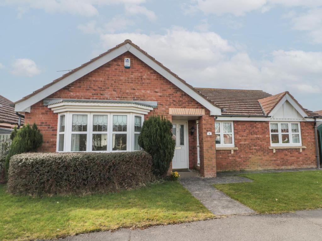 ein rotes Backsteinhaus mit einer weißen Tür in der Unterkunft Bray Nook, 7 Craikewells in Bridlington