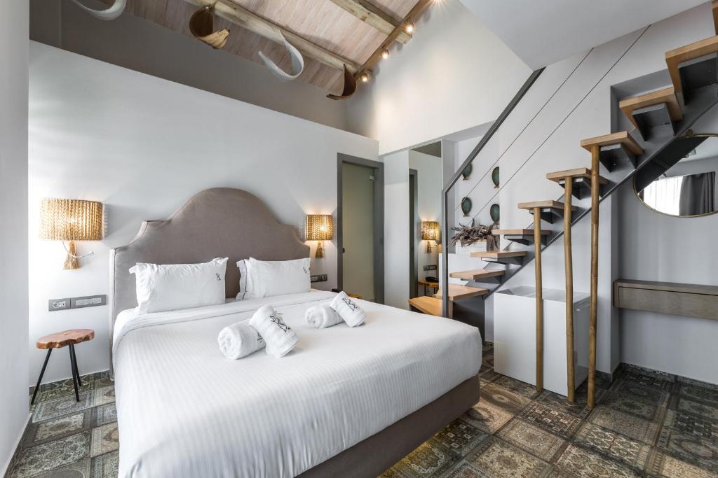 sypialnia z dużym białym łóżkiem z 2 poduszkami w obiekcie Blue Carpet Luxury Suites w mieście Pefkochori