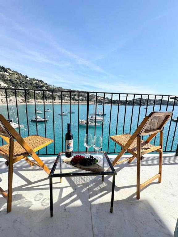 - une terrasse avec 2 chaises et une table avec une bouteille de vin dans l'établissement NEPTUNE AP4453 By Riviera Holiday Homes, à Villefranche-sur-Mer