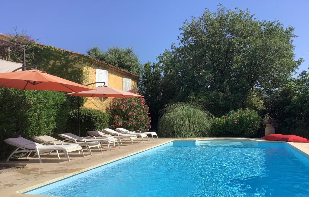 - une piscine avec des chaises et des parasols à côté d'une maison dans l'établissement La Sokina, à Grimaud
