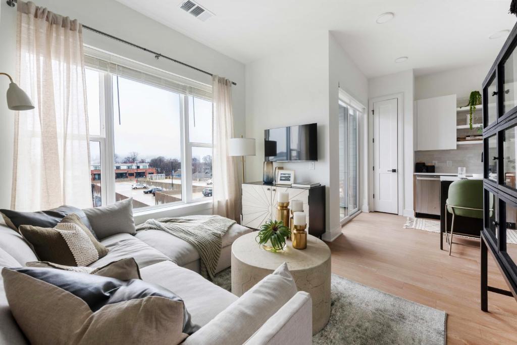 a living room with a white couch and a large window at Jade Junction in Atlanta