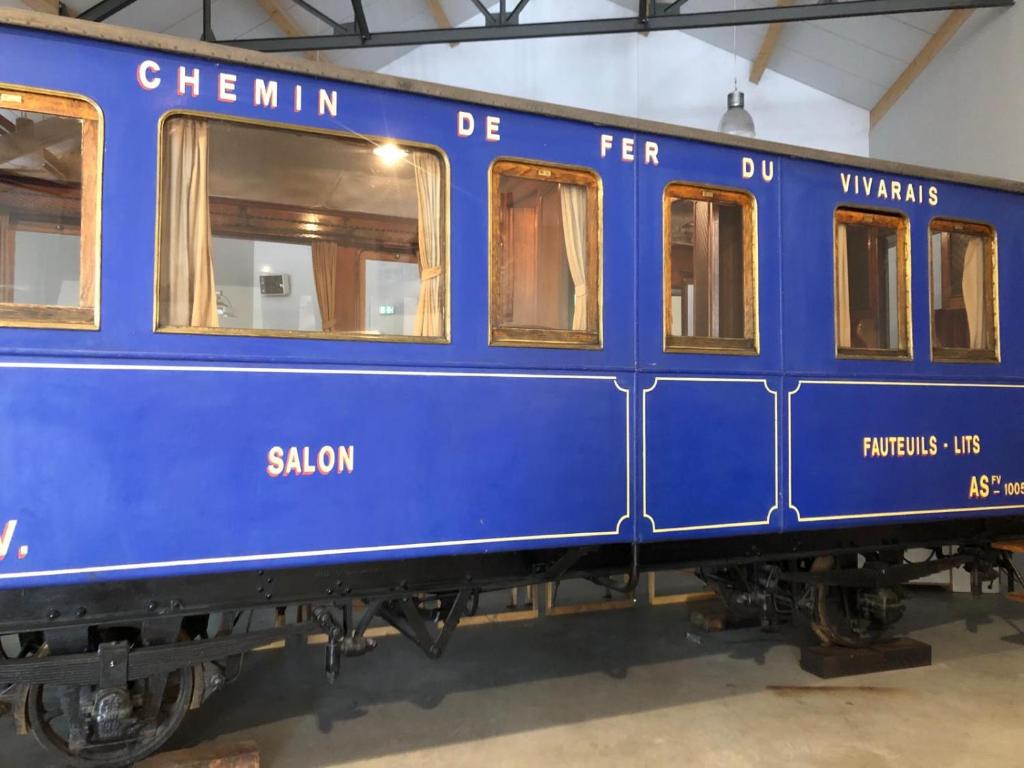 a blue train car sitting inside of a building at Camping Les Berges Du Doux in Colombier-le-Vieux