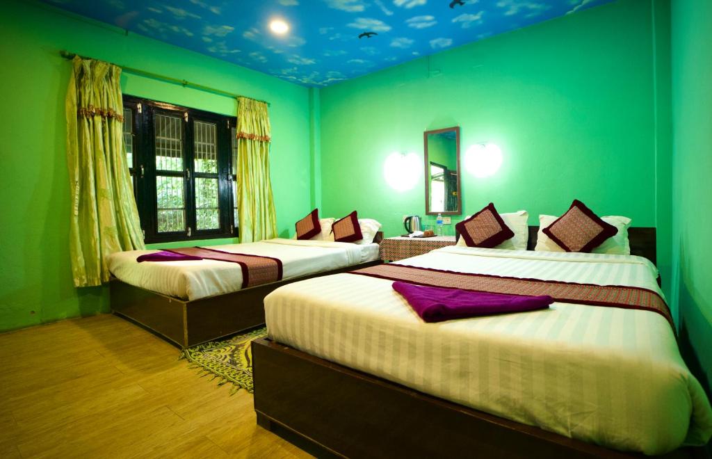 Postel nebo postele na pokoji v ubytování Chitwan Gaida Lodge