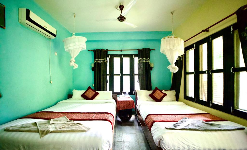 Postel nebo postele na pokoji v ubytování Chitwan Gaida Lodge