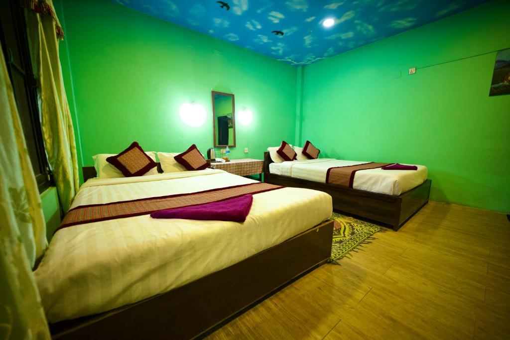 Postel nebo postele na pokoji v ubytování Chitwan Gaida Lodge