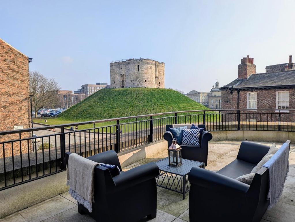 a balcony with couches and a castle in the background at The Old Fire Station Luxury Apartment in York