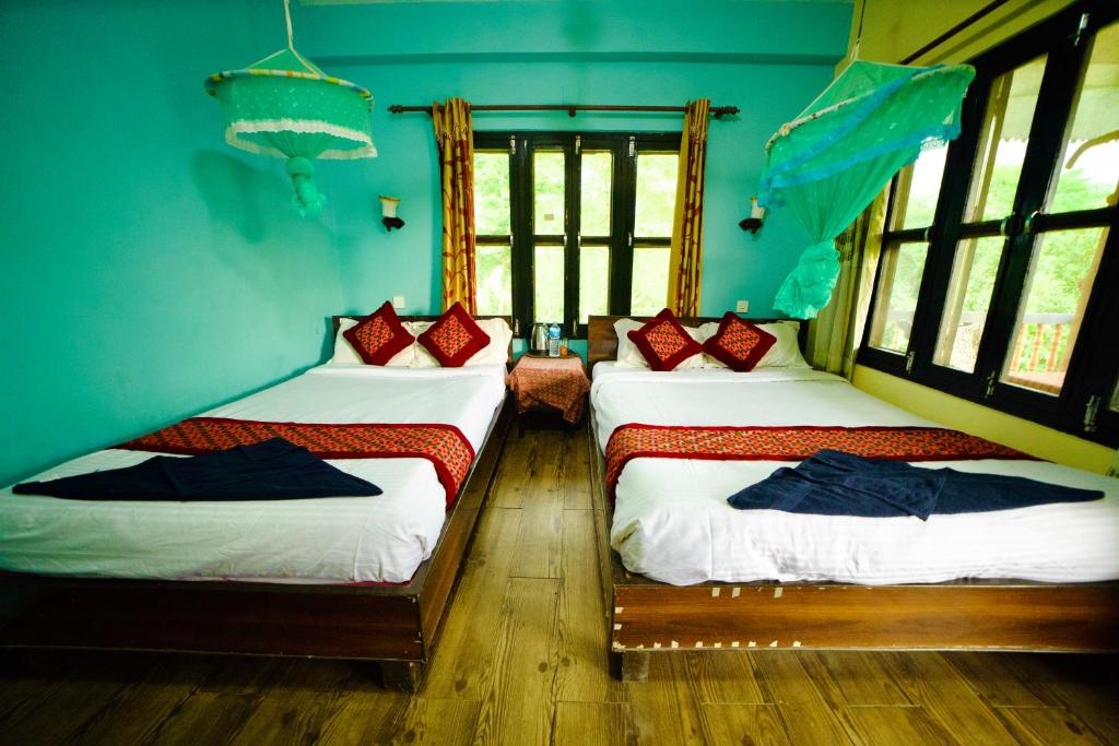 Postel nebo postele na pokoji v ubytování Chitwan Gaida Lodge