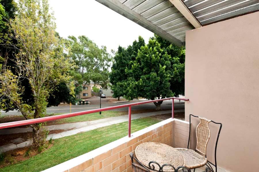 een balkon met een tafel en stoelen aan een muur bij Cunningham Terrace 9 in Perth