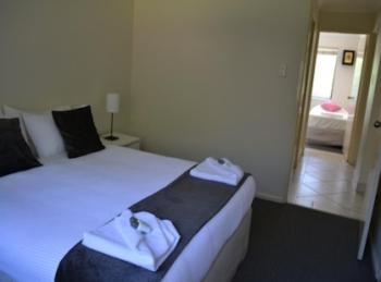 柏斯的住宿－福雷斯特街度假屋，一间卧室配有一张床,上面有两条毛巾