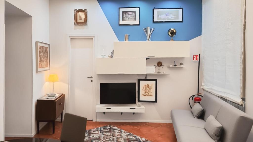 Una sala de estar con un sofá y un televisor. en Domus Chiara al Colosseo, en Roma