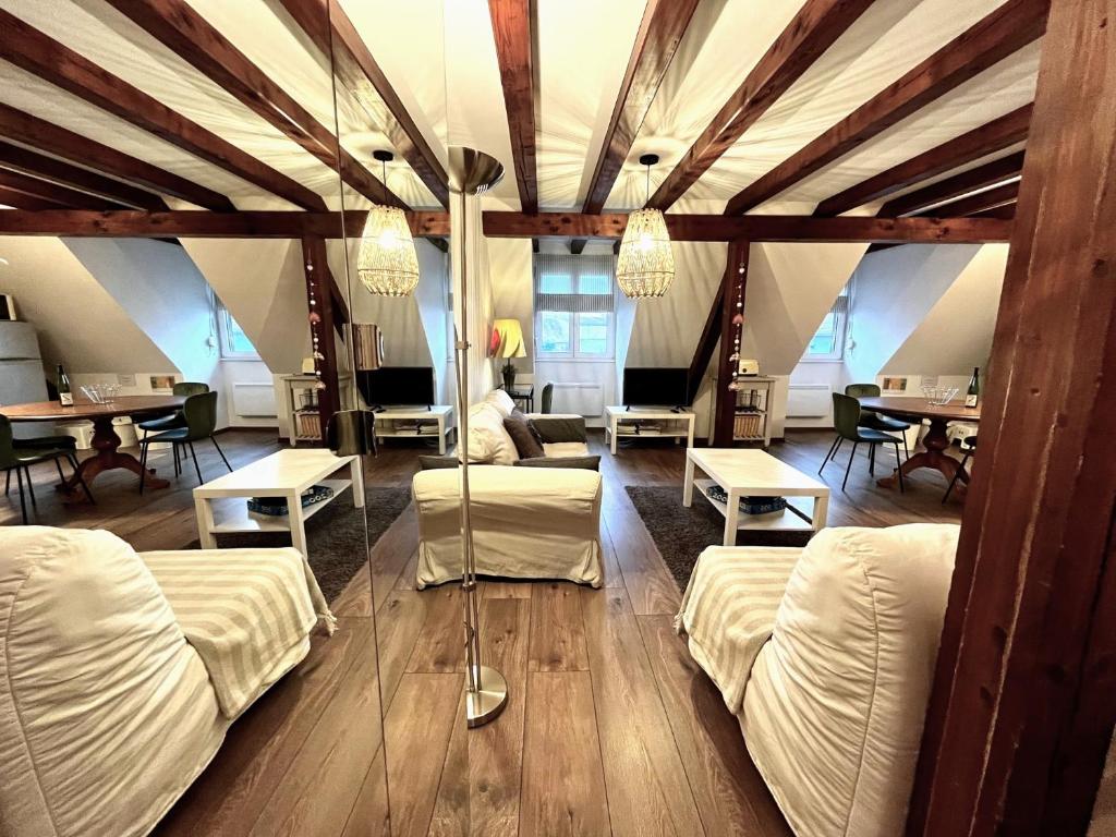 Cette grande chambre comprend 2 lits et des tables. dans l'établissement Gite Ophelia dans Domaine Viticole - Maison ZEYSSOLFF, à Gertwiller