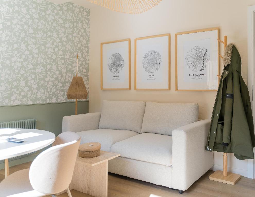 a living room with a white couch and a table at Le Gabriel in Strasbourg