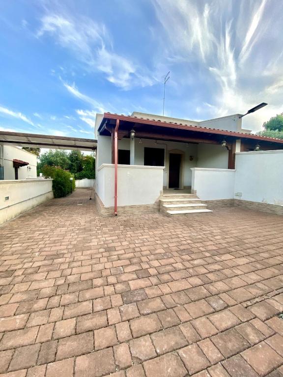 a building with a brick driveway in front of it at Casa Vacanze - Villa Claudia in Leporano Marina