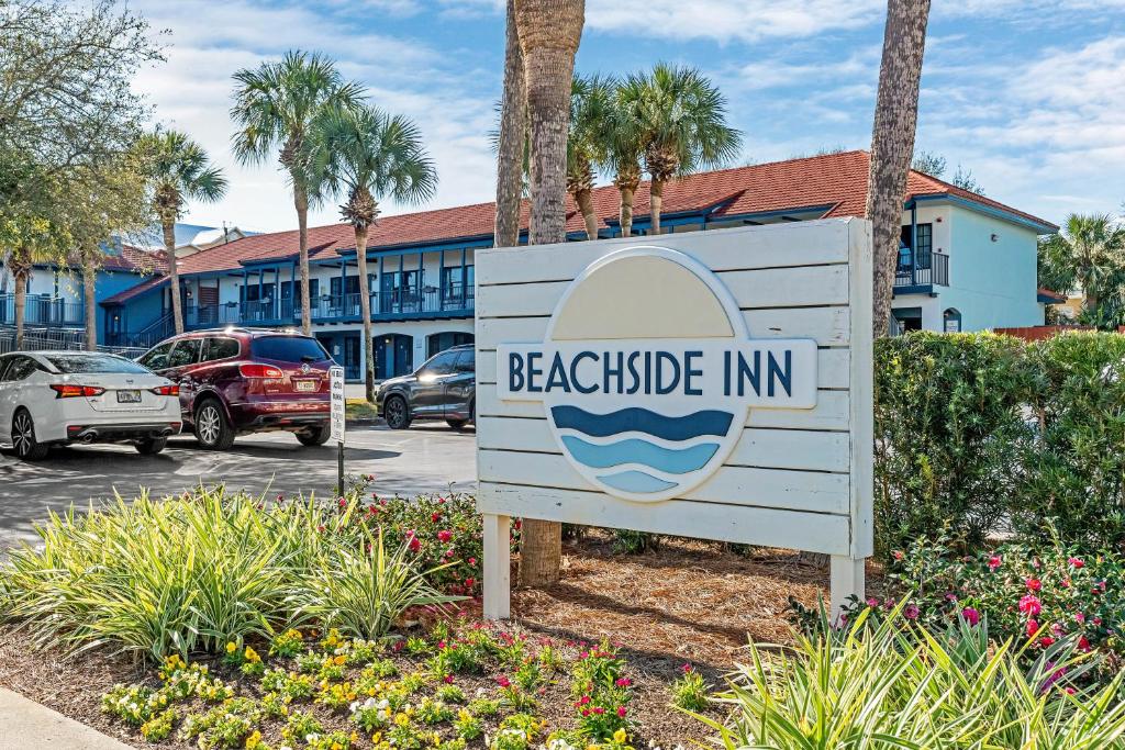 ein Schild für ein Gasthaus am Strand auf einem Parkplatz in der Unterkunft Beachside Inn in Destin