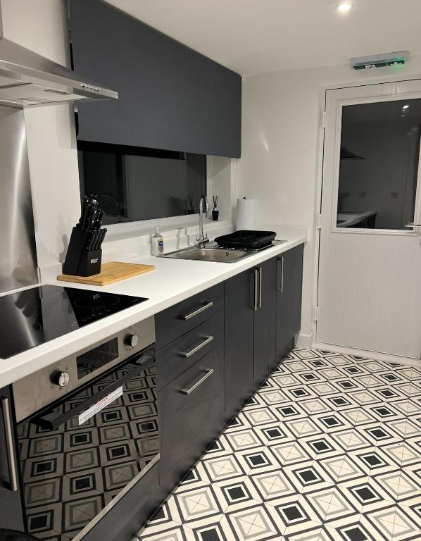 a kitchen with black and white tile floors and a counter at Room in Melrose Shared House in Hull
