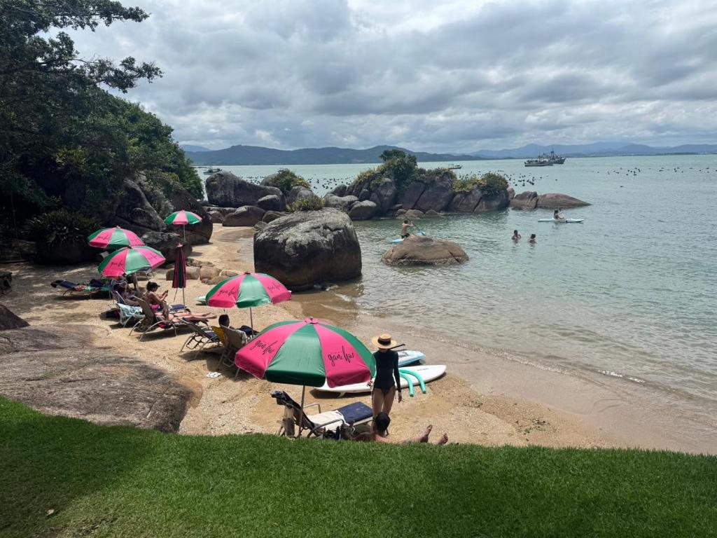 a group of people sitting on a beach with umbrellas at Villa in Governador Celso Ramos