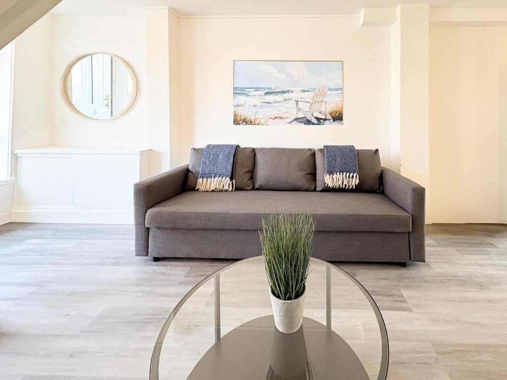 Una sala de estar con un sofá y una mesa de cristal. en Pavilion - Beachfront Property, en Gorleston-on-Sea