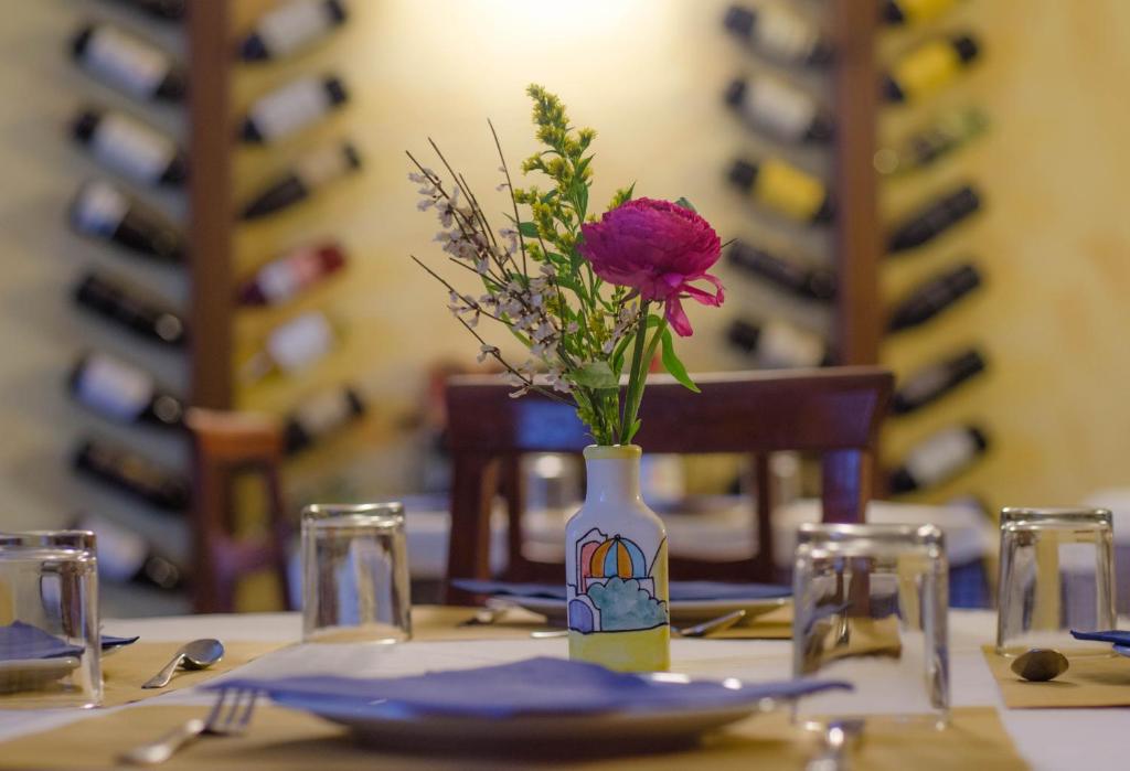 un vase avec une fleur sur une table dans l'établissement Hotel Chez Toi, à Oulx