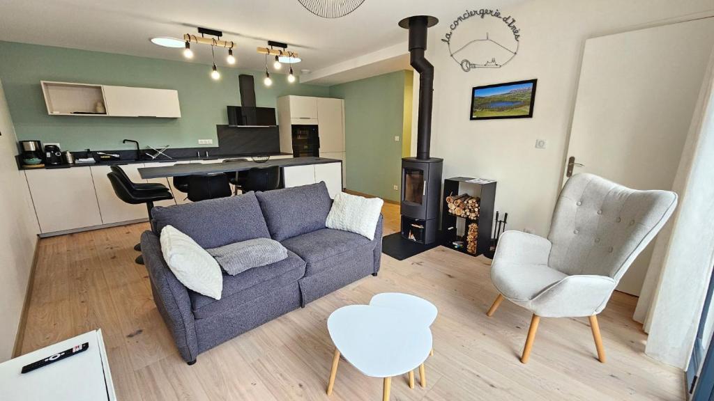 a living room with a couch and chairs and a kitchen at Le Bon'abry #Balnéo#Terrasse#Garage in Orcines