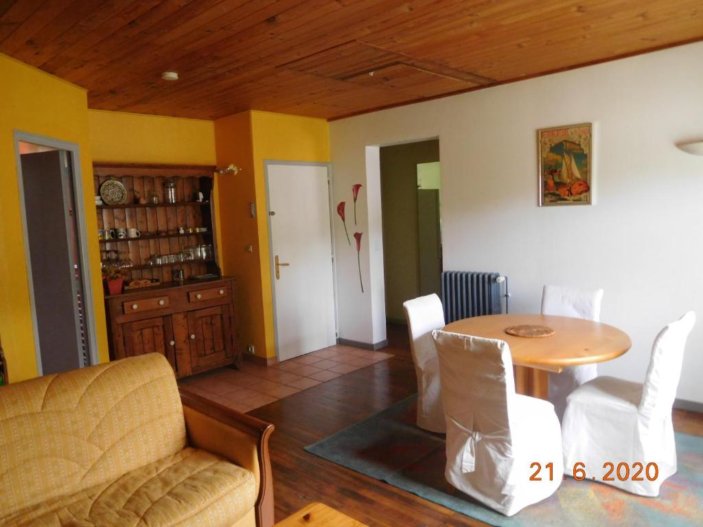 un salon avec une table et une salle à manger dans l'établissement l'olivier, à Bouguenais