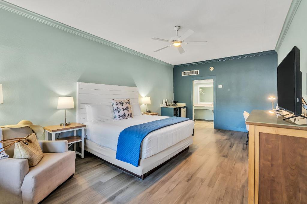 ein Schlafzimmer mit einem Bett, einem Fernseher und einer Couch in der Unterkunft Beachside Inn in Destin