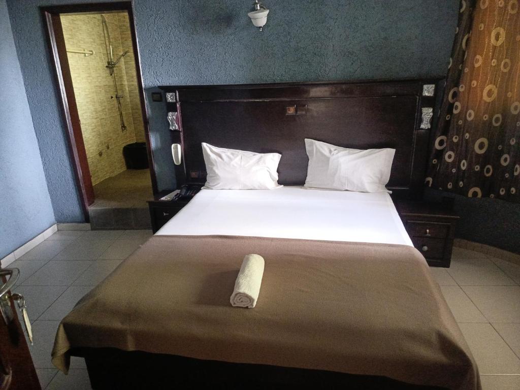 a bedroom with a bed with a roll on it at HOTEL GEORGES 5 Bénin in Cotonou