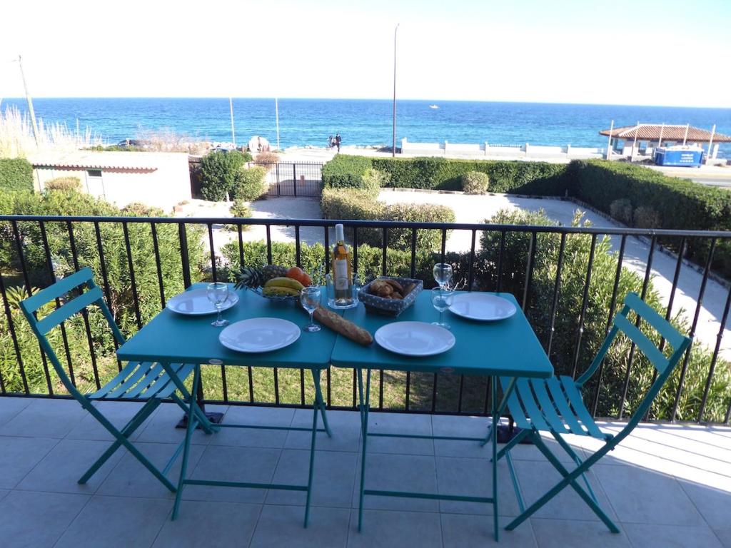 une table sur un balcon avec l'océan en arrière-plan dans l'établissement Appartement mer, 6 couchages Sainte Maxime, à Sainte-Maxime